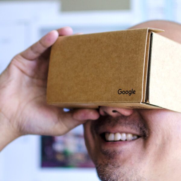 Man holding box like VR goggles with Google logo on it