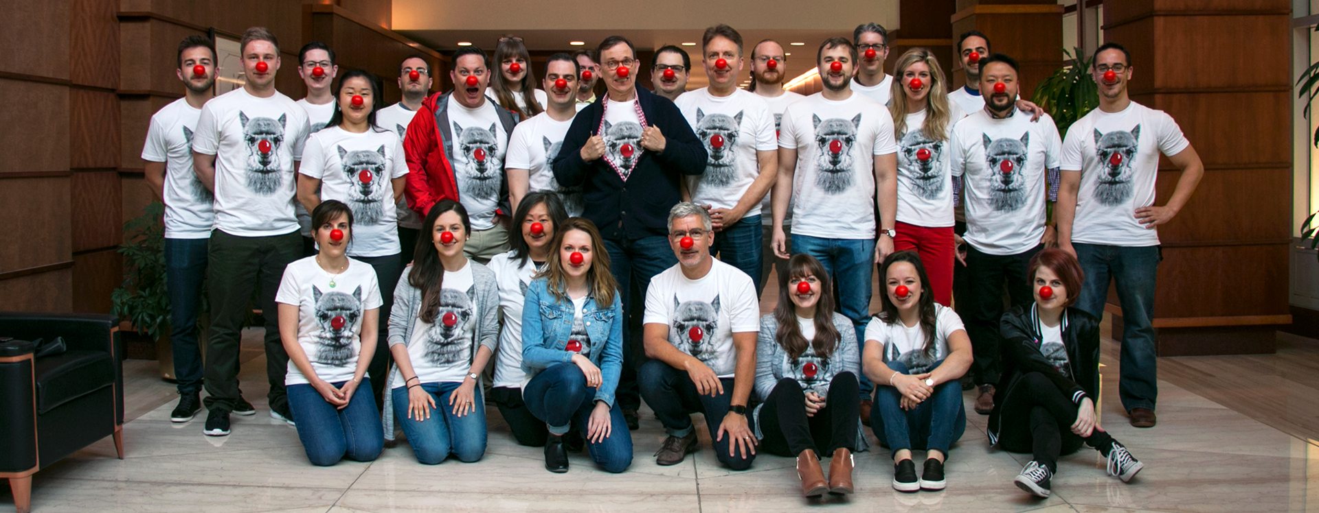 Grafik employees wearing a lama tshirt with a red nose, while they are wearing red noses