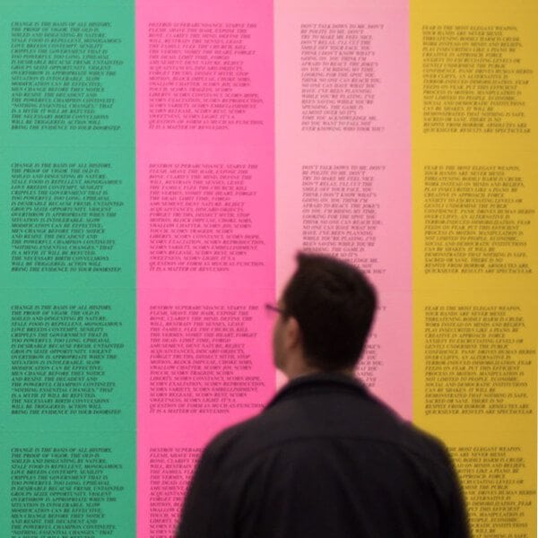 Man looking at a wall with 4 different colors